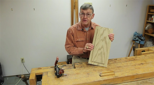 Ernie Conover decorating a wooden panel