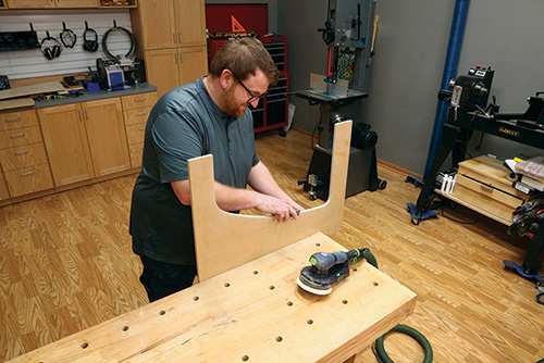 Hand sanding edges of shelf template