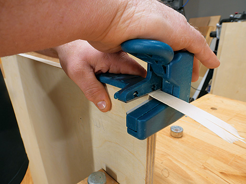 Cutting veneer tape end with veneer cutter