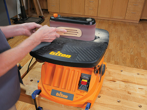 Using belt sander to shape bottom of spurtle head